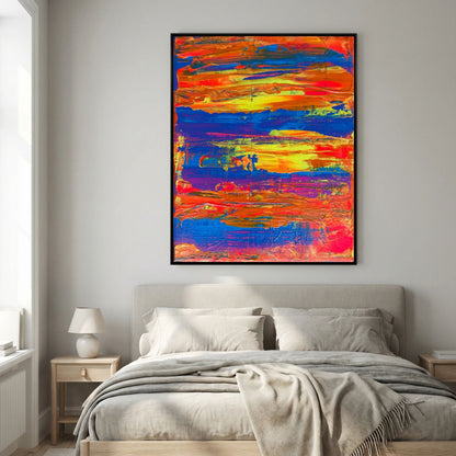After the Heat van Tim Hupkes in een zwarte lijst boven een bed met grijs beddengoed, de oranje, gele en blauwe strepen fleuren de slaapkamermuur op