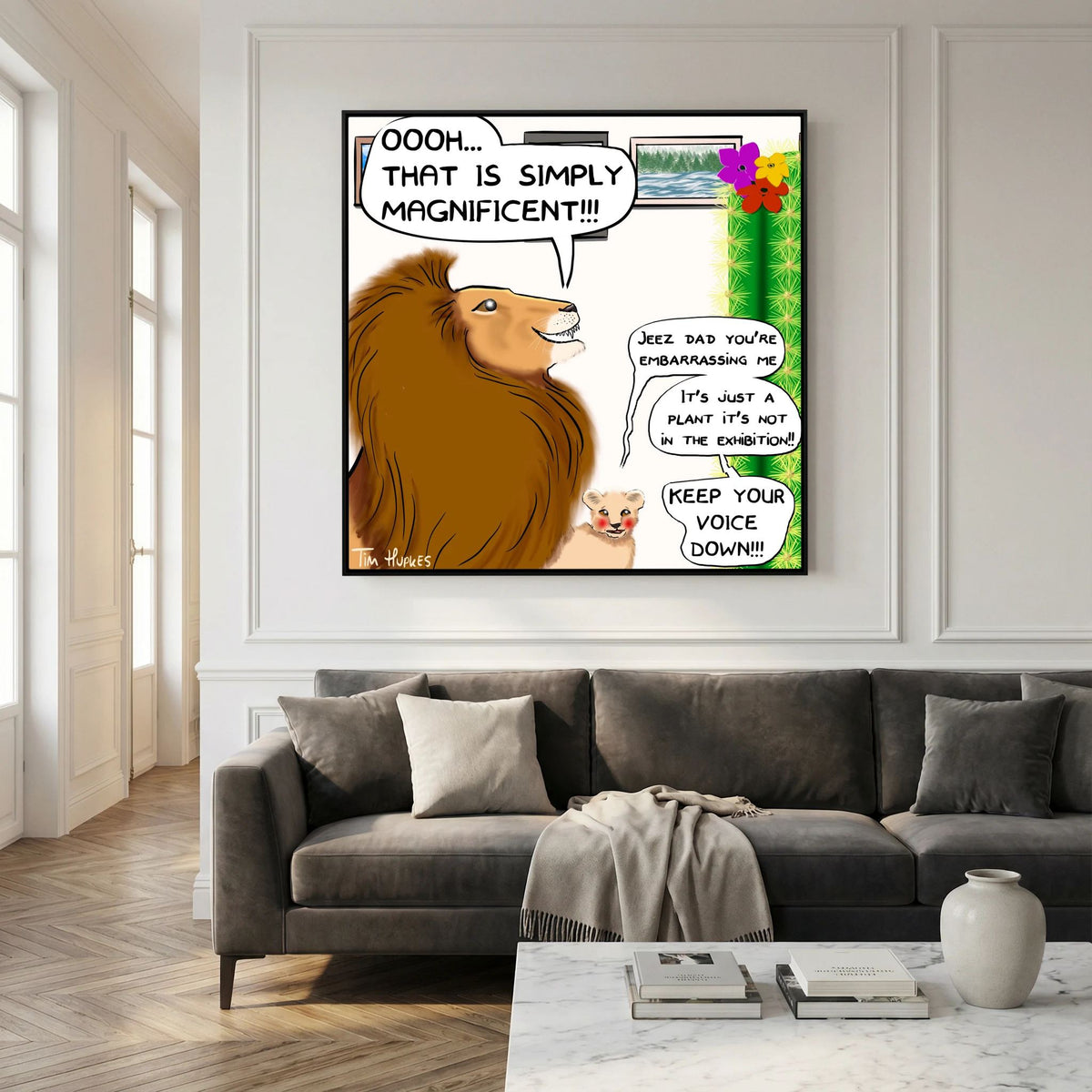 Black-framed Faux Pas by Tim Hupkes comic of a lion and cub hanging over a dark grey sofa and marble coffee table