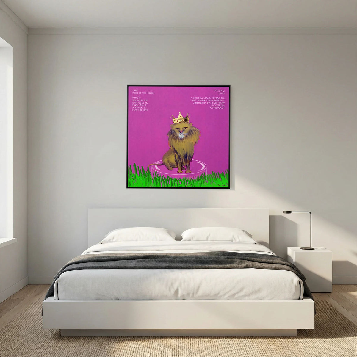 The King canvas print in a black frame above a white bed with a low headboard in a bedroom