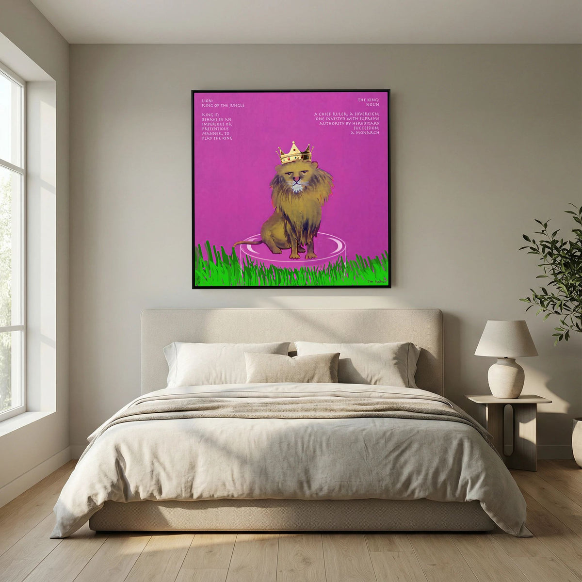 The King canvas print in a black frame above a cream upholstered bed in a bedroom