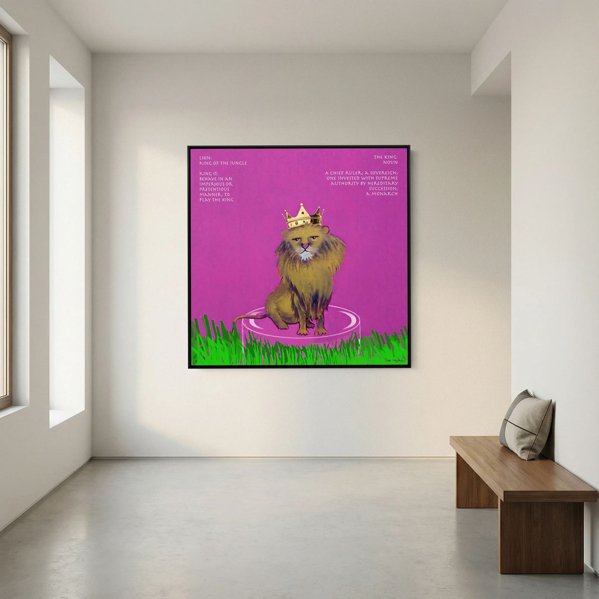 The King canvas print in a black frame on a white wall above a wooden bench in an empty hall