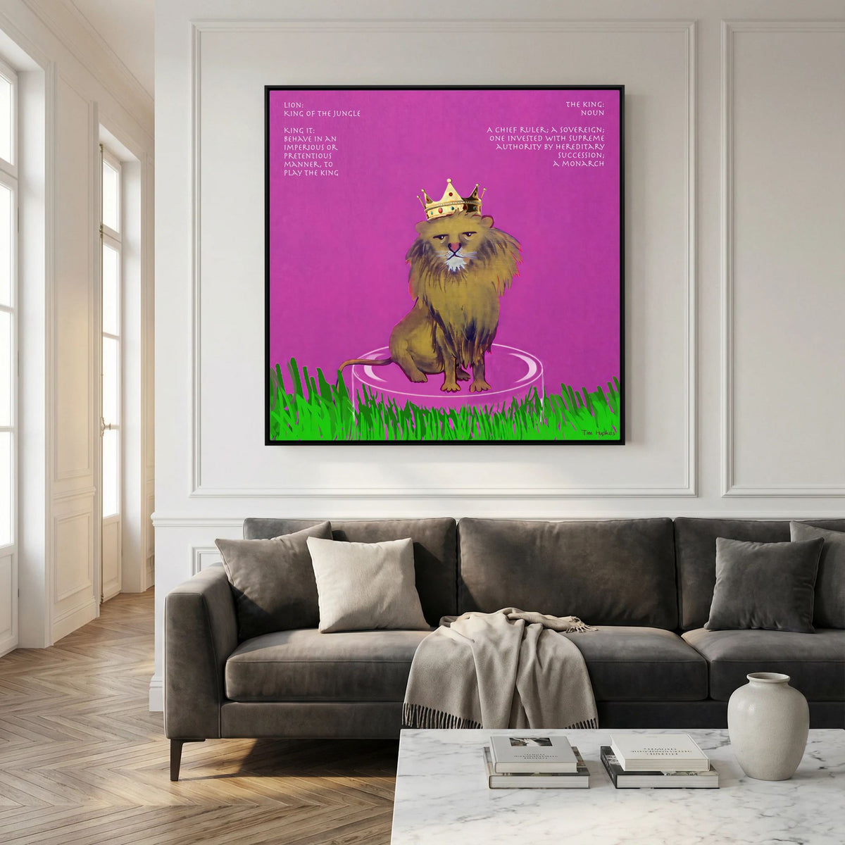 The King canvas print in a black frame above a dark grey sofa in a living room with panelled walls