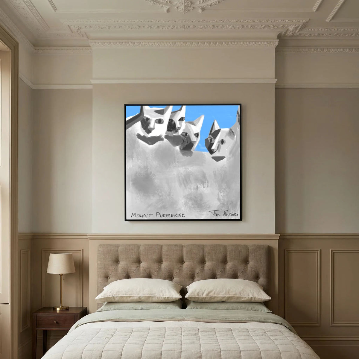 Mount Purrsmore by Tim Hupkes canvas print in a black frame above a tufted headboard and a made bed in a classic room with panelled walls
