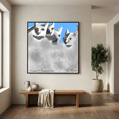 Black-framed Mount Purrsmore by Tim Hupkes canvas print above a wooden bench with ceramic jugs and a throw, next to a potted tree