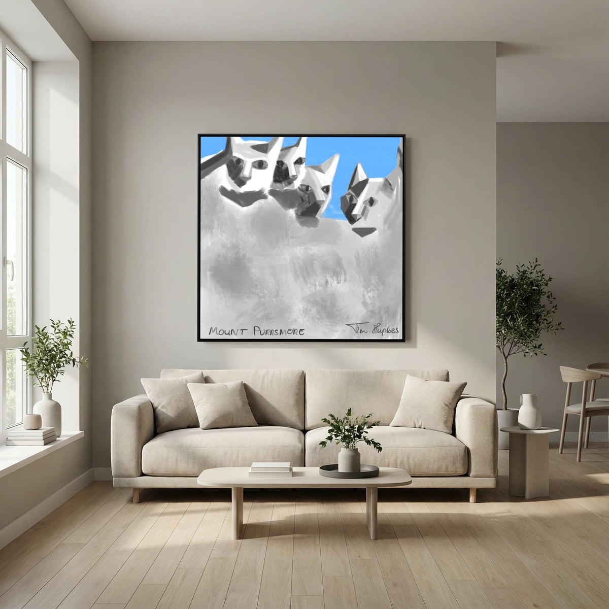 Mount Purrsmore by Tim Hupkes canvas print in a black frame above a cream sofa with a low oval coffee table in a calm living room