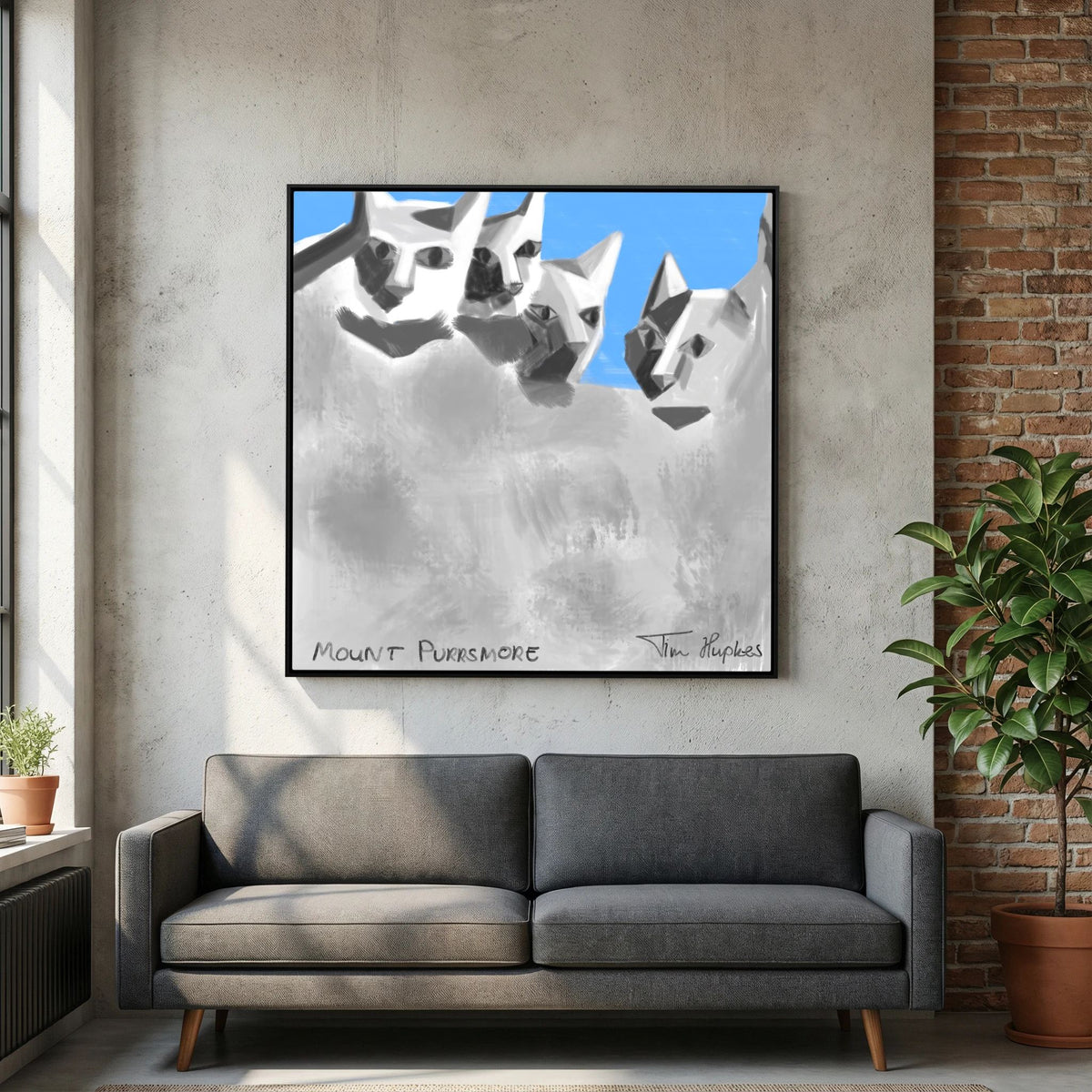Mount Purrsmore by Tim Hupkes canvas print in a black frame above a dark grey sofa, with a concrete wall and brick wall alongside