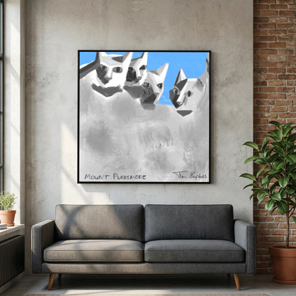 Mount Purrsmore by Tim Hupkes canvas print in a black frame above a dark grey sofa, with a concrete wall and brick wall alongside