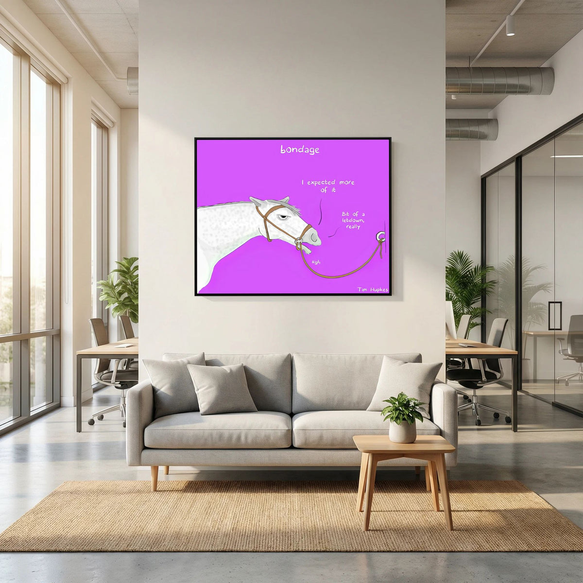 Bondage canvas print in a black frame above a light grey sofa in an open-plan office lounge